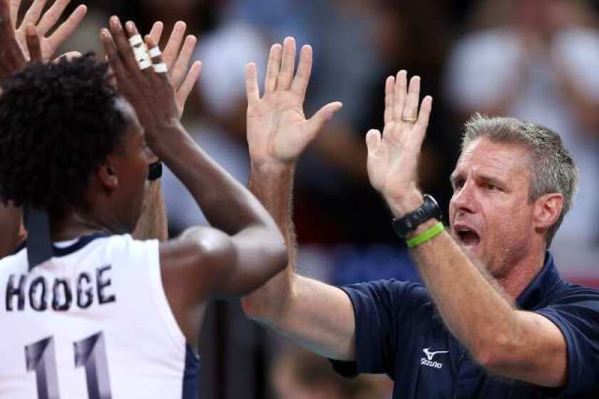 Assistant coach Karch Kiraly of the United States celebrates a win over China with Megan Hodge.