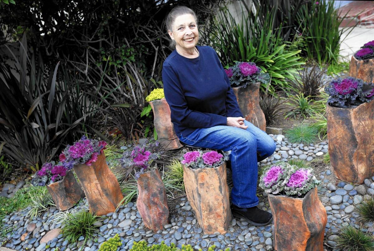 Ceramic artist Stefani Gruenberg sits among the planters she made for the artistic garden at her Los Angeles home.