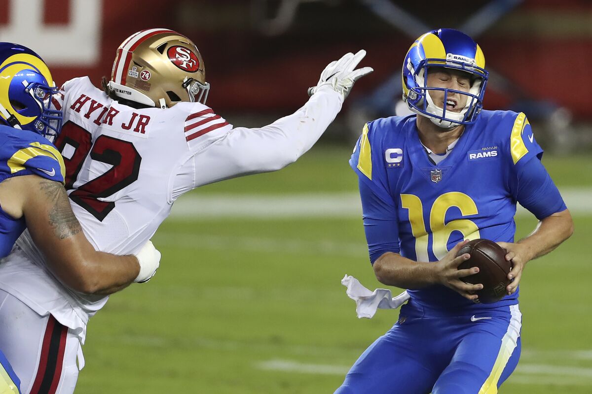 The San Francisco 49ers' pass rush pressures Rams quarterback Jared Goff.  