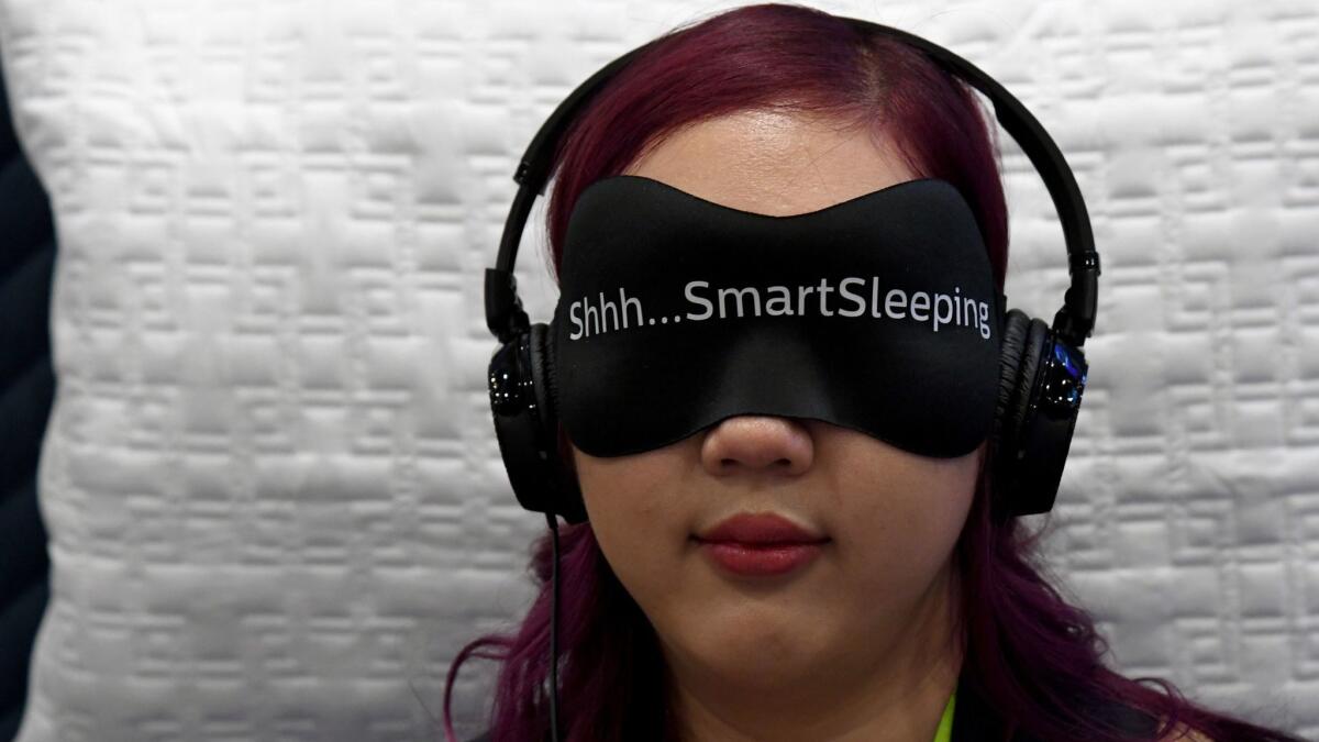 Angela Pan of Minnesota tries the Philips SmartSleep wearable sleep improvement system at CES at the Sands Expo & Convention Center in Las Vegas.