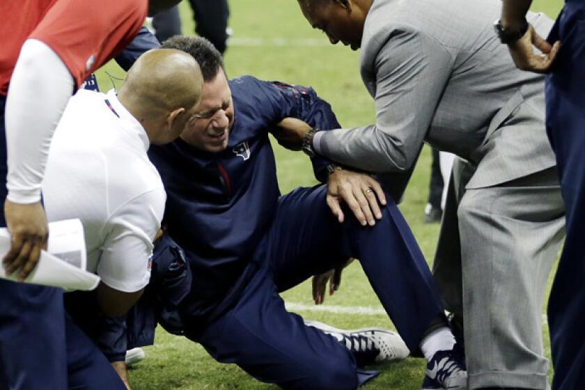 Texans Coach Gary Kubiak is given assistance by medical personnel and staff members after collapsing on the field at halftime Sunday night at Reliant Stadium in Houston.