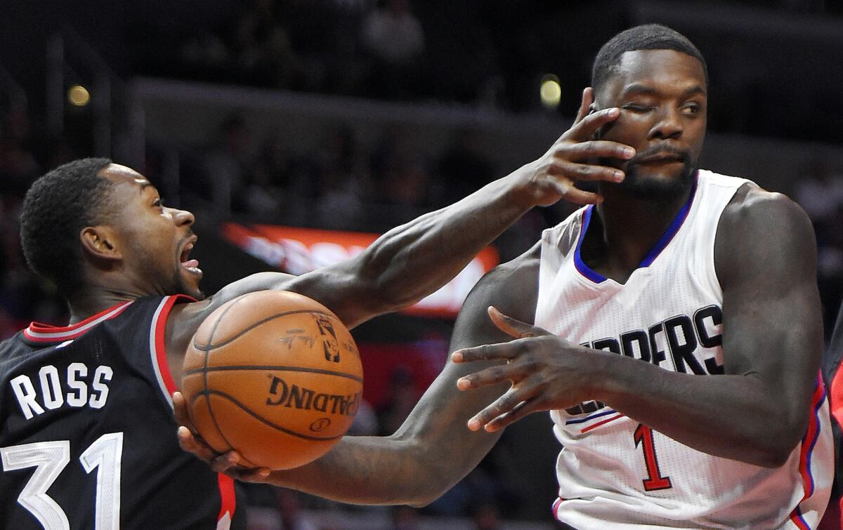 Clippers forward Lance Stephenson is hit in the face by Raptors forward Terrence Ross while trying to make a pass in the first half Sunday at Staples Center.