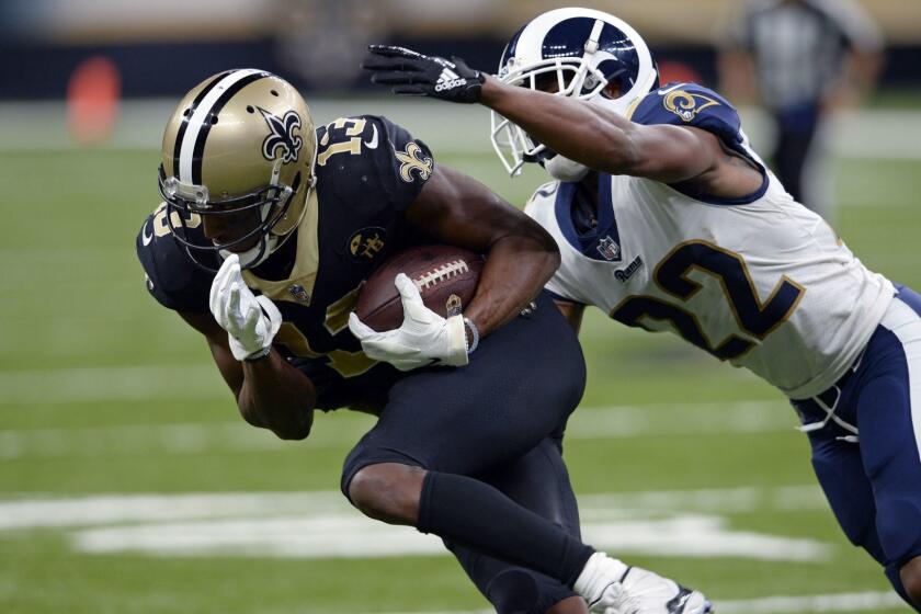 Los Angeles Rams cornerback Marcus Peters (22) tries to tackle New Orleans Saints wide receiver Michael Thomas (13) in the second half of an NFL football game in New Orleans, Sunday, Nov. 4, 2018. (AP Photo/Bill Feig)