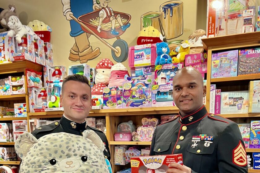 Maj. Thomas Evers, l, and Staff Sgt. Carlos Cedena, oversaw pick up of $100,700 Toys for Tots gifts from an anonymous donor.