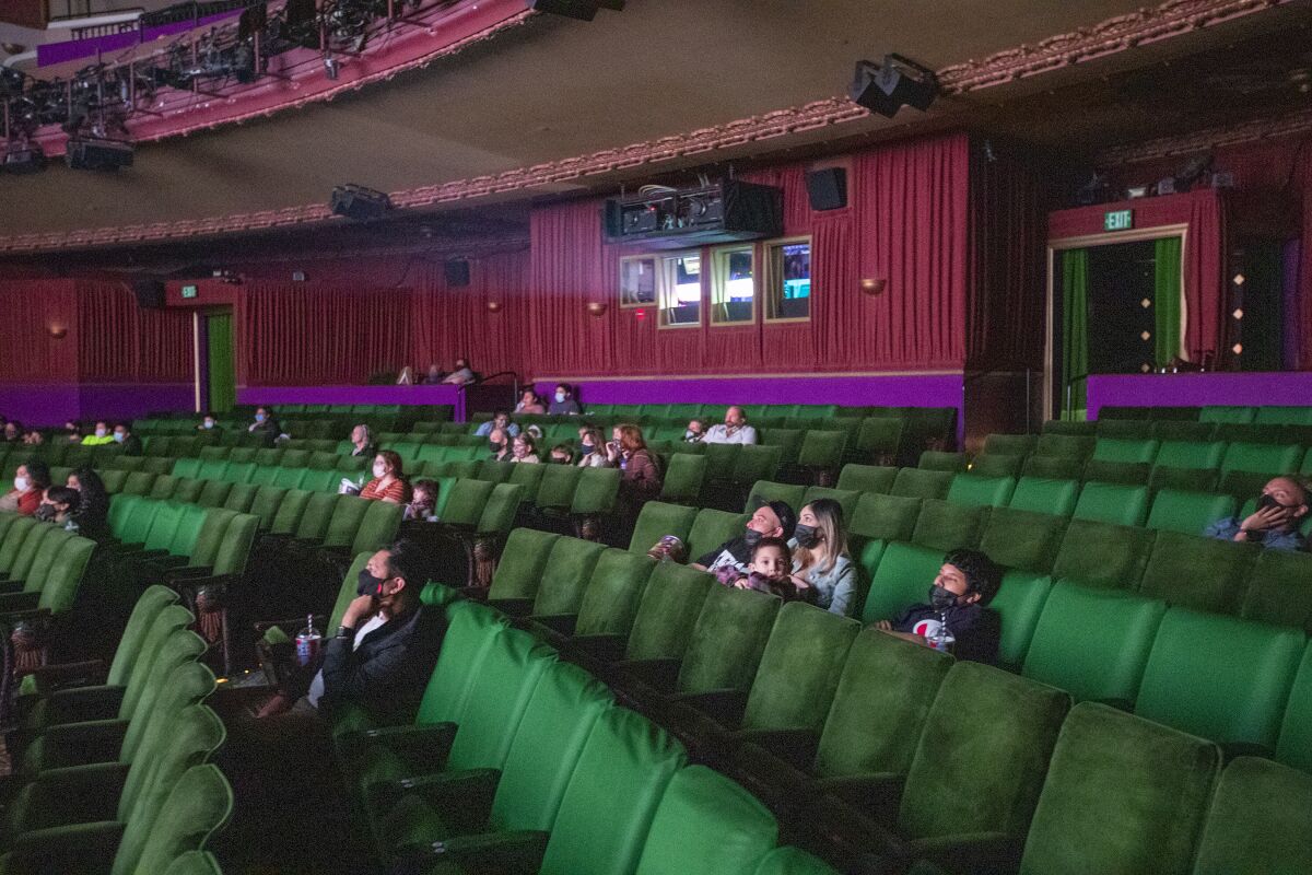 Movie-goers spread out with COVID-19 safety precautions in effect at The El Capitan Theatre in Hollywood.