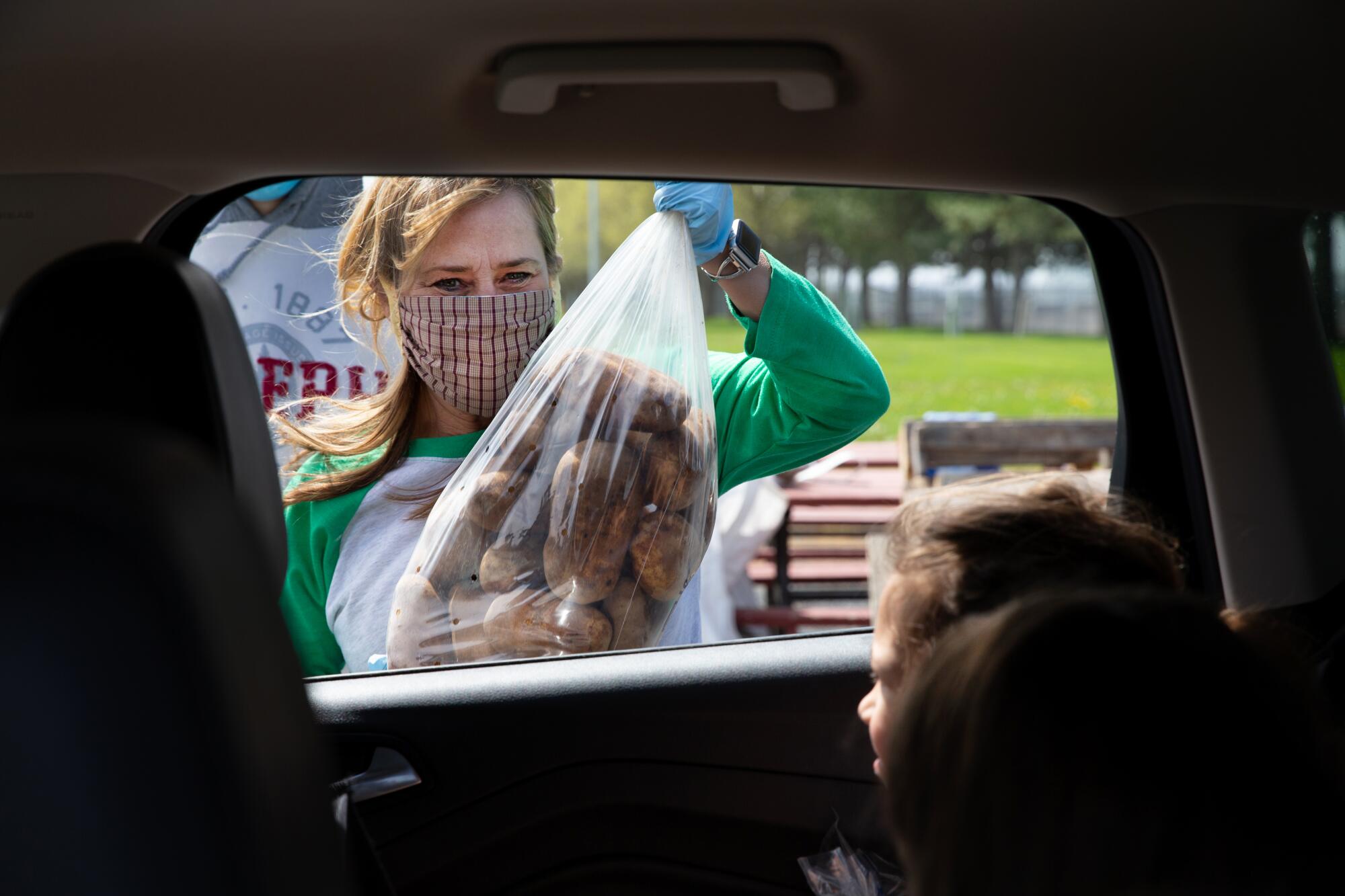 Angie Griffith gives away 15-pound bags of potatoes -- two bags per family -- during a free potato event at the Grant County Fairgrounds in Moses Lake, Wash.