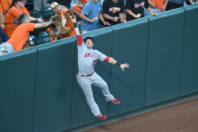 Angels left fielder Daniel Nava (25) catches a fly ball hit by Orioles infielder Manny Machado to rob him of a home run in the first inning.