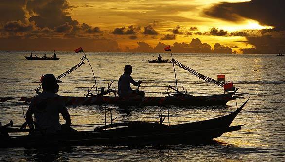 Fishermen paddle their boats off the coast of Menado, Indonesia, site this week of the World Ocean Conference, a meeting of officials from governments and independent organizations representing more than 120 Pacific and Southeast Asian countries to discuss strategies for marine protection.