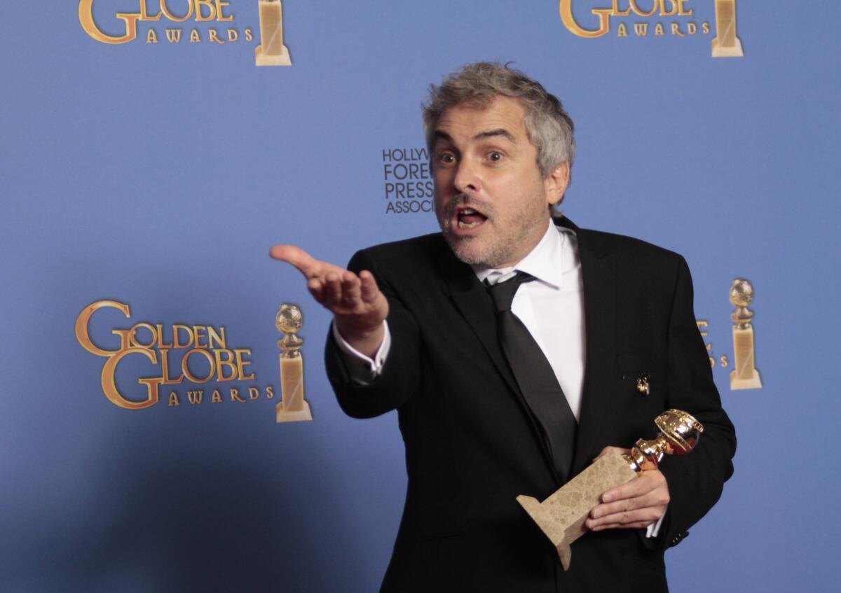 Director Alfonso Cuaró holds his Golden Globe in the deadline room at the 71st Annual Golden Globe Awards show at the Beverly Hilton Hotel on Jan. 12, 2014.