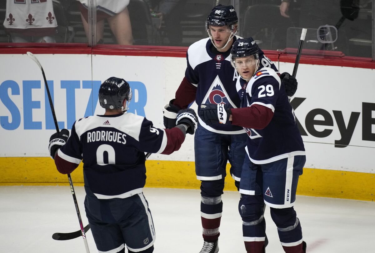 Colorado Avalanche center Nathan MacKinnon, right, is congratulated by right wing Mikko Rantanen and center Evan Rodrigues, left, after scoring in the first period of an NHL hockey game against the Dallas Stars, Saturday, April 1, 2023, in Denver. (AP Photo/David Zalubowski)