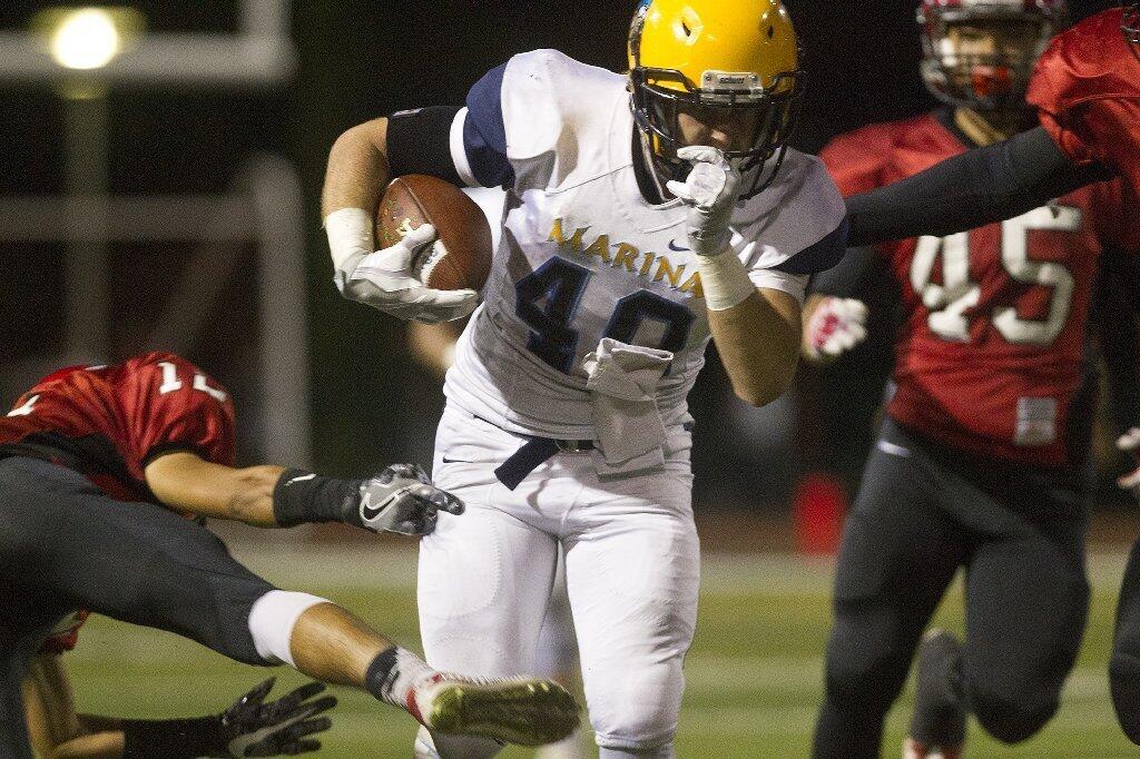 Marina High's Blaine Riederich(40) breaks a tackle as he carries the ball during the first half against Westminster.
