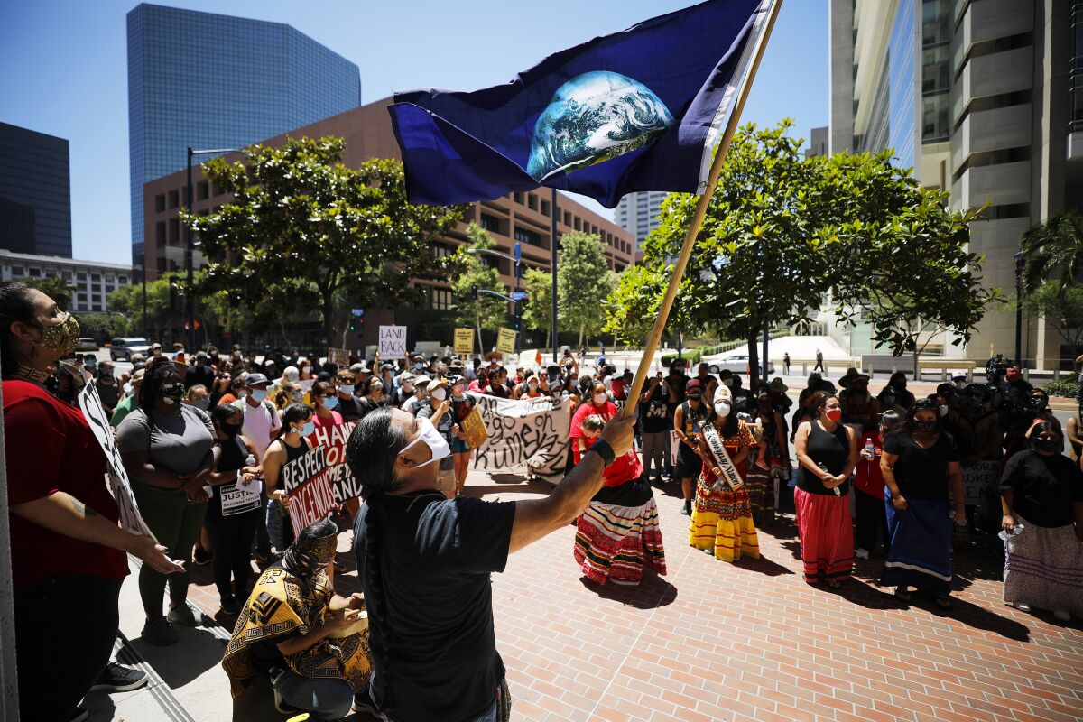 Bobby Wallace of the Barona Band of Mission Indians holds flag at protest on July 5, 2020.