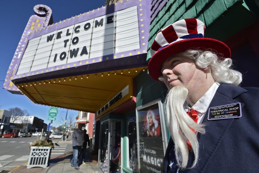 A man dressed as Uncle Sam walks near a costume shop in West Des Moines on Sunday, a day before the Iowa caucus, the first nominating test presidential candidates face.