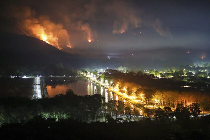 Fire and smoke rise from a forest fire at Nakhon Nayok province province, 114 kilometers (70 miles) northeast of Bangkok. Thailand, Thursday, March 30, 2023. The fire had engulfed large areas of two mountains by Thursday, and the authorities were trying to contain its spread. (AP Photo/Nava Sangthong)