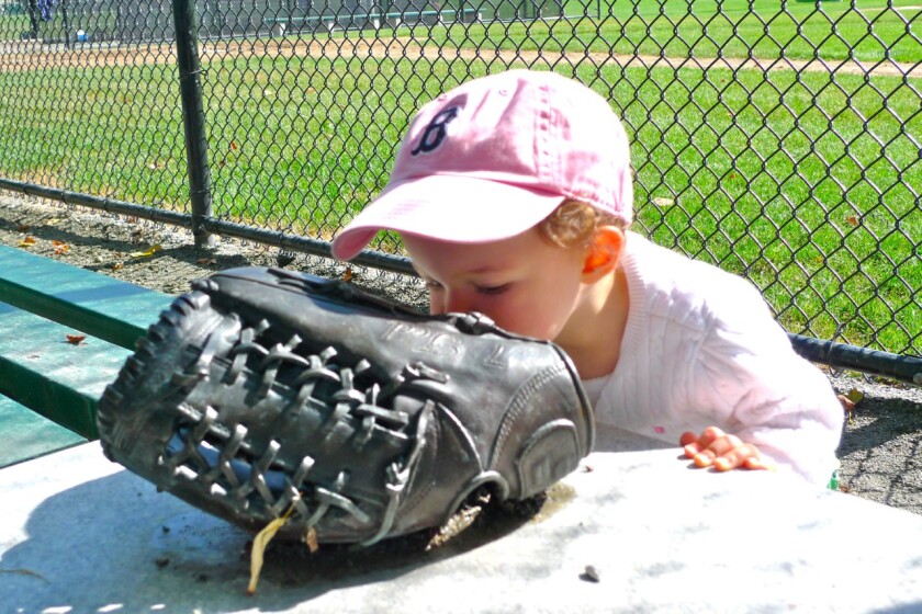 Rowena, daughter of Teddy Ebersol's sister, Sunshine Lewis, kisses the glove commemorating Teddy.