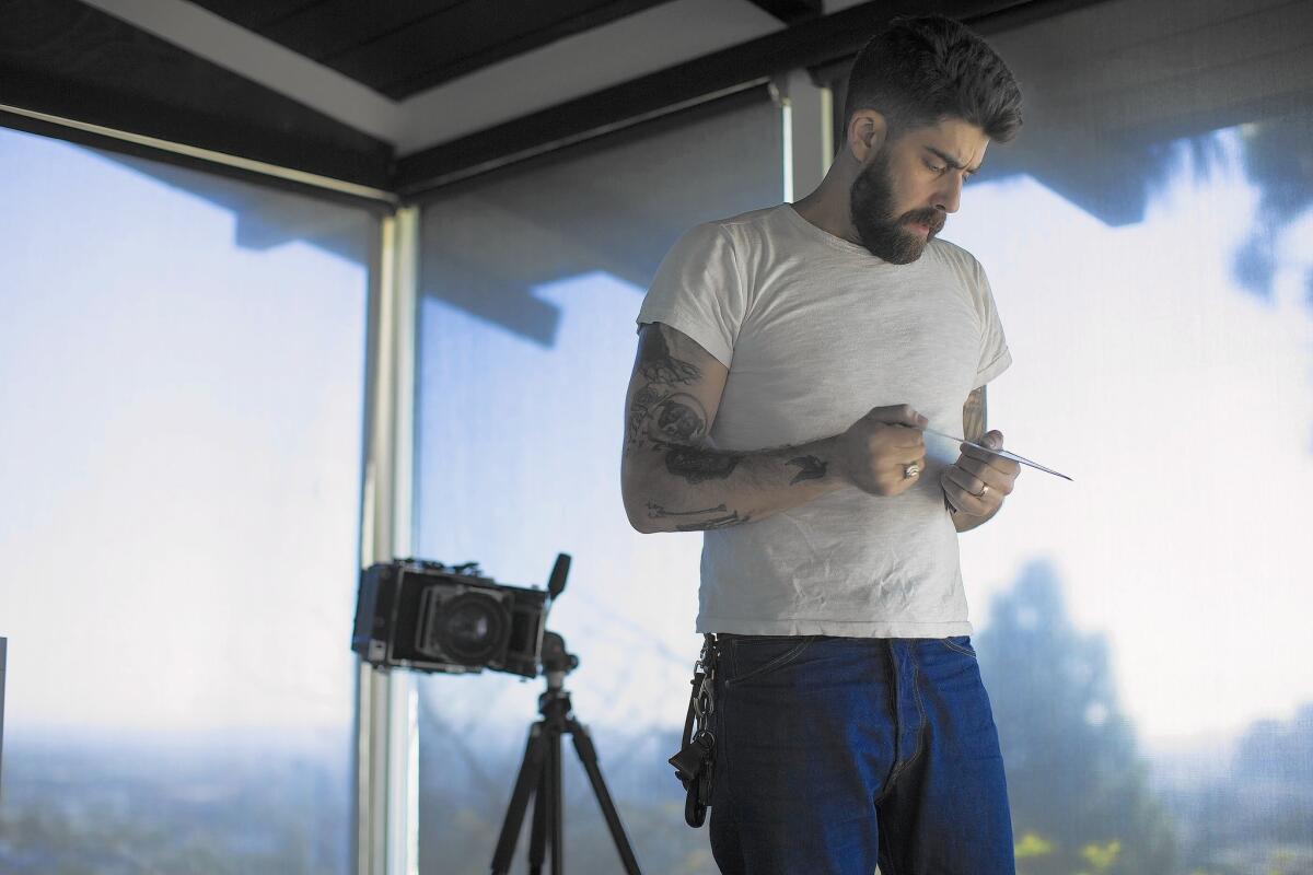 Adam Goldberg looks at a Polaroid after photographing his wife and a family friend with his 4 X 5 camera at his home on Sept. 29, 2015 in Los Angeles. He is very passionate about photography and still uses film cameras.