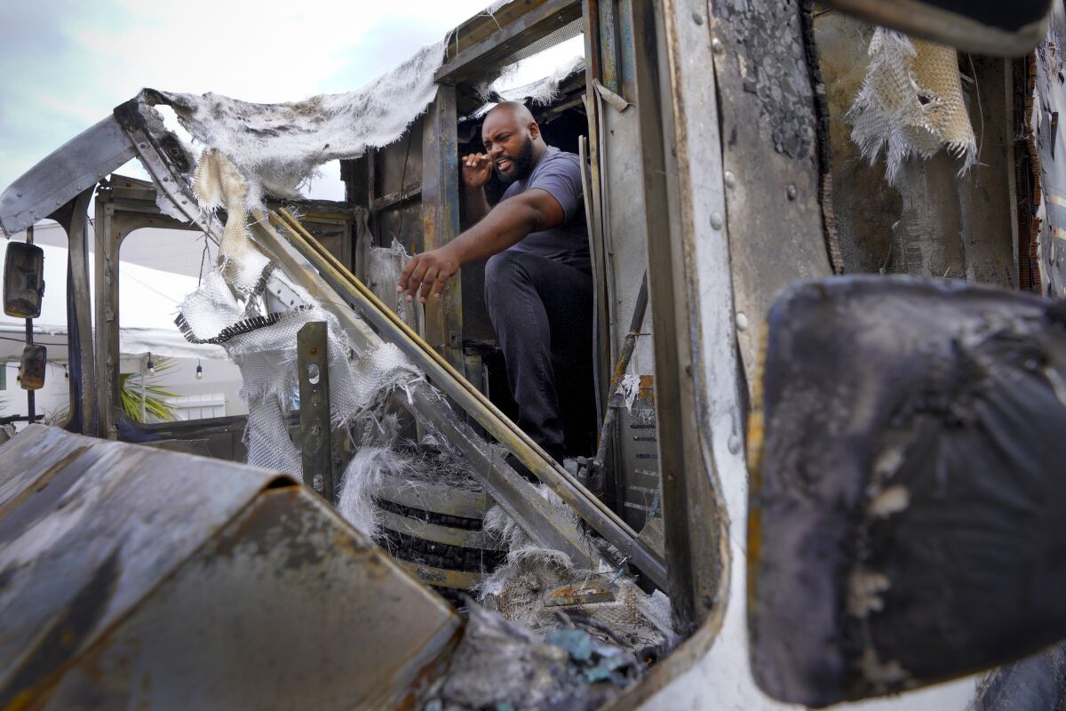 Avonte Hartsfield makes his way from the kitchen of his burned food truck to the driver's cab that was destroyed in a fire. 
