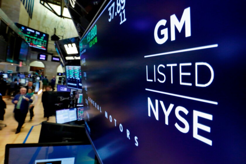 The logo for General Motors appears above a trading post on the floor of the New York Stock Exchange.