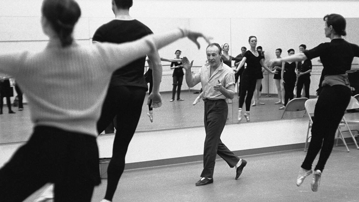 A vintage photo of a choreographer instructing ballet dancers in a classroom