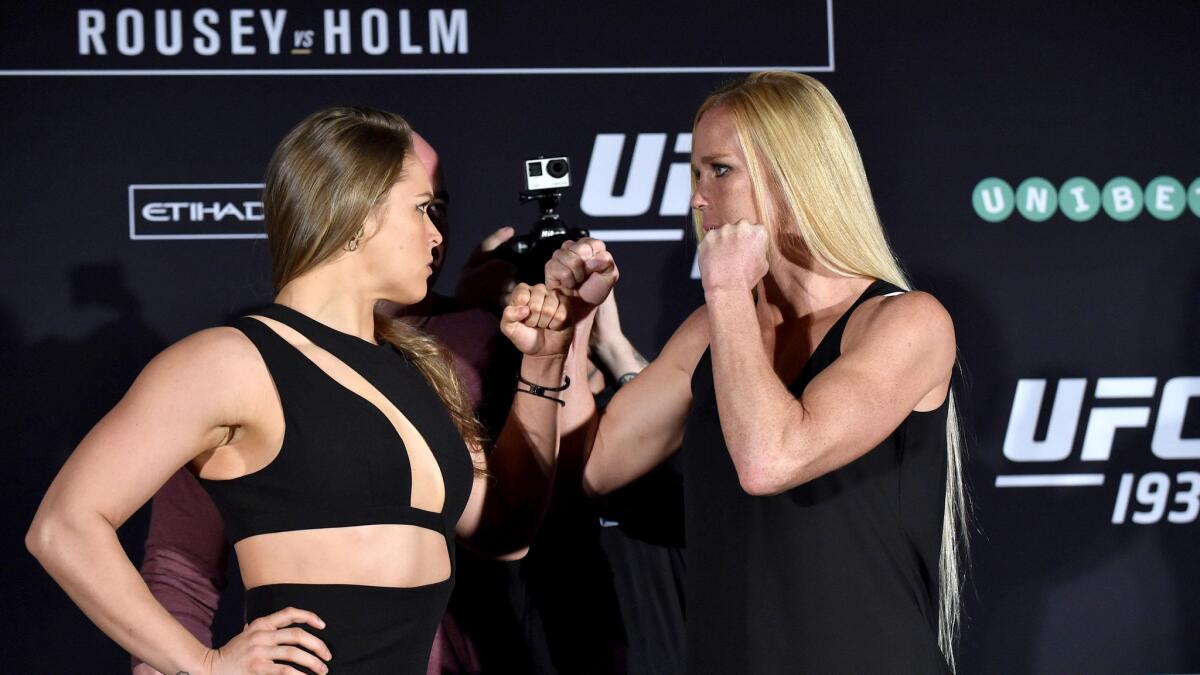 Ronda Rousey, left, and Holly Holm strike the usual pose after their weigh-in Friday for UFC 193.