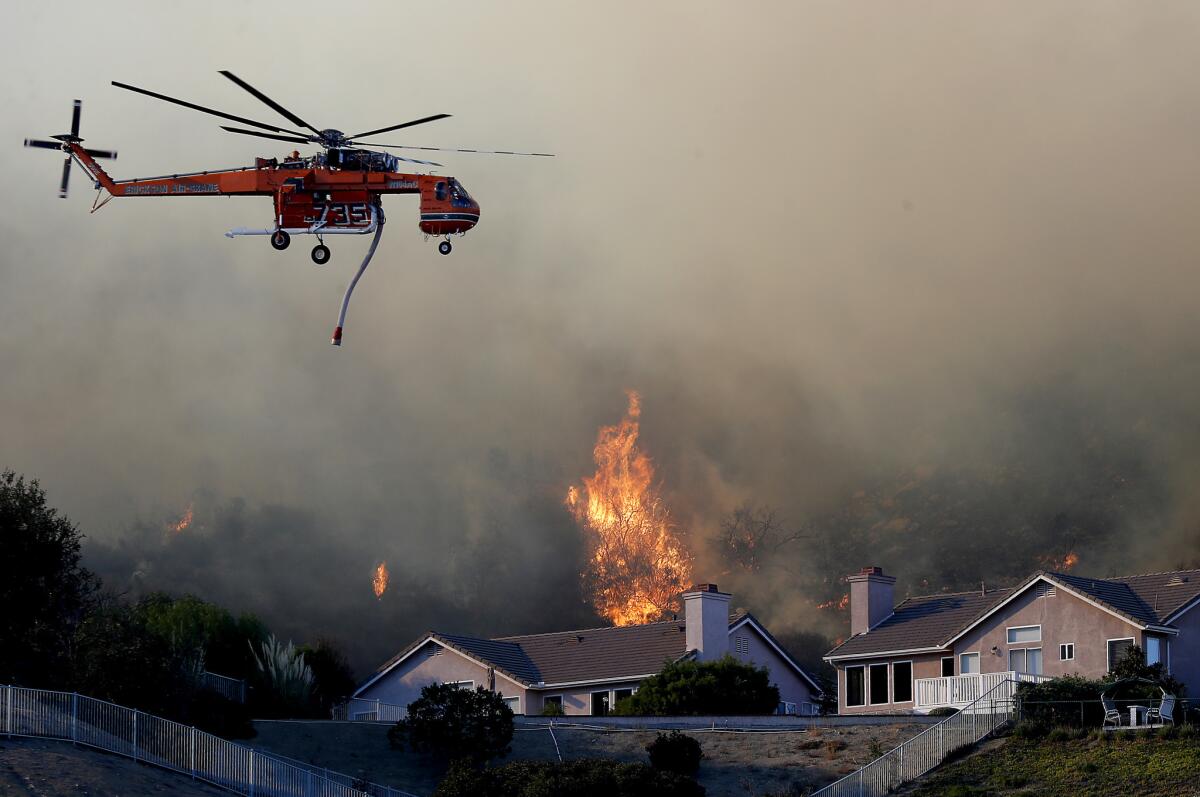 The Woolsey fire burns near homes in West Hills on Friday.