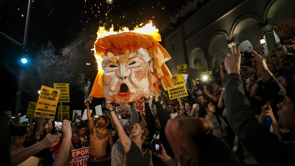 Protesters burn an effigy of Donald Trump outside Los Angeles City Hall on Wednesday.