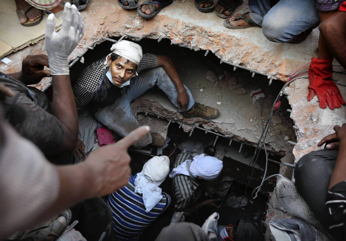 A rescuer looks out from a hole cut in the concrete as he searches for survivors at a collapsed building in Savar, Bangladesh. At least 238 people were killed.