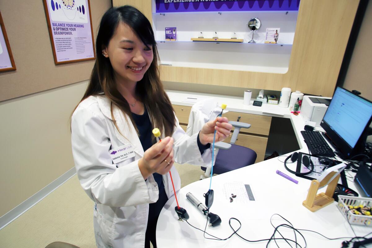 Dr. Katherine Yeh holds a pair of "insert head phones."