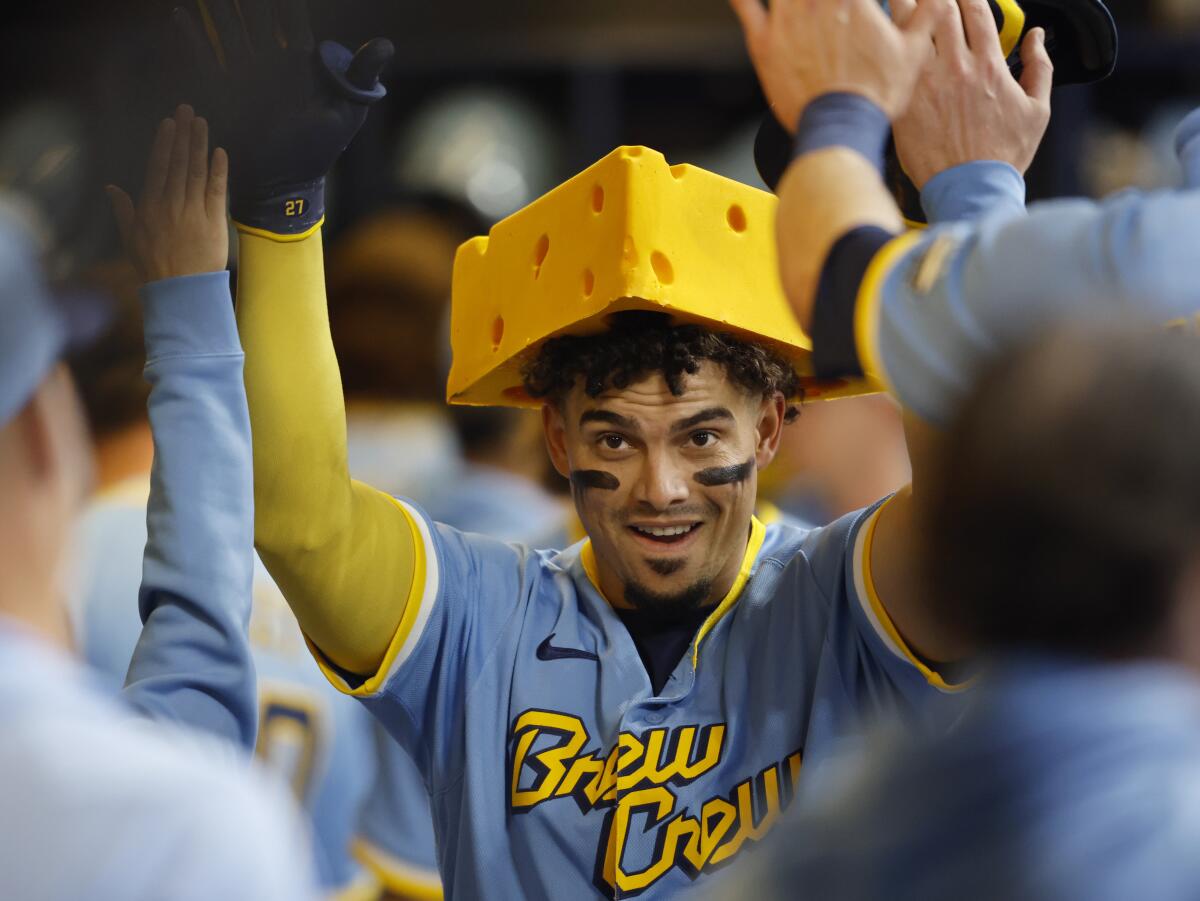 The Brewers' Willy Adames wears a cheesehead in the dugout after his first-inning homer against the Angels.