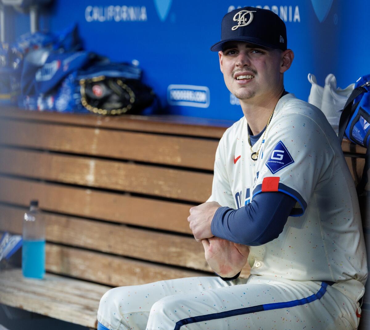 Dodgers starting pitcher River Ryan stretches his right throwing arm in the dugout during the top of the fifth inning. 