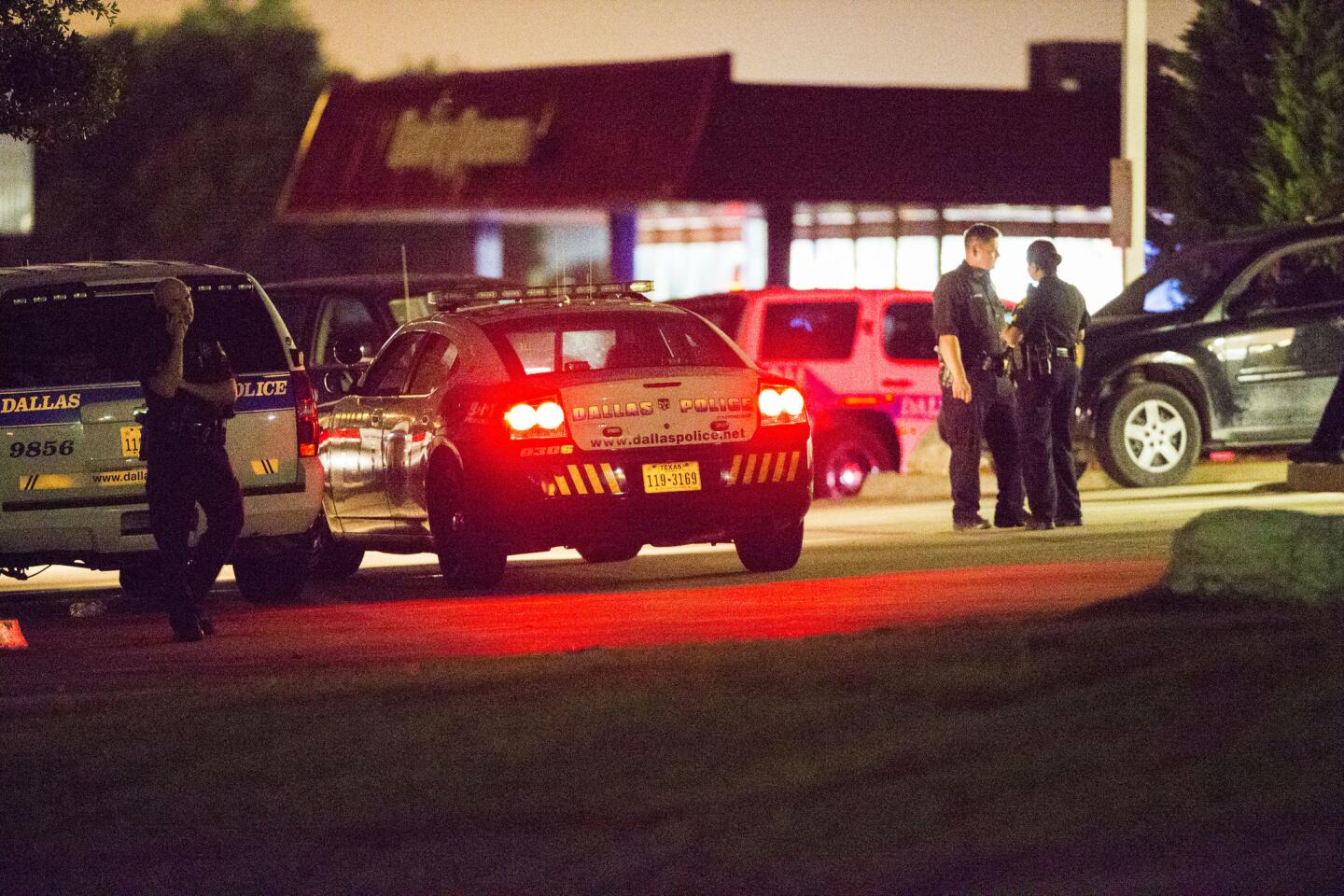 Dallas police gather at the intersection of Interstate 45 and E Palestine Street, where they cornered a suspect in a van on Saturday, June 13, 2015 in Hutchins, Texas. Multiple gunmen toting automatic weapons opened fire on officers outside Dallas Police headquarters early Saturday morning, before one man fled the scene being chased by police in what witnesses described as an armored van, according to Dallas Police Chief David Brown.