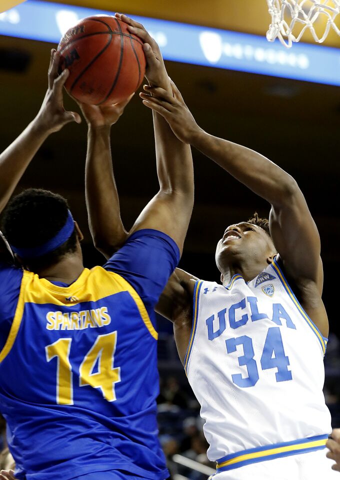 UCLA guard David Singleton battles San Jose State center Samuel Japhet-Mathias for a rebound.