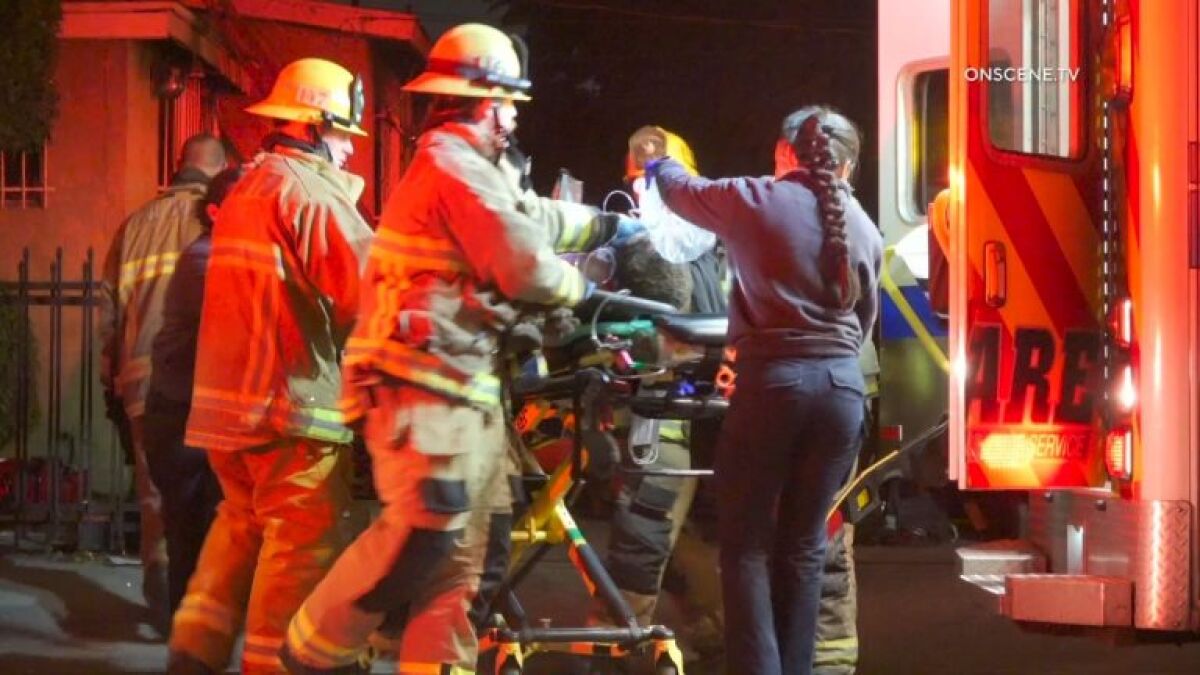 Los Angeles County first responder transport a patient from a house fire in South Los Angeles 