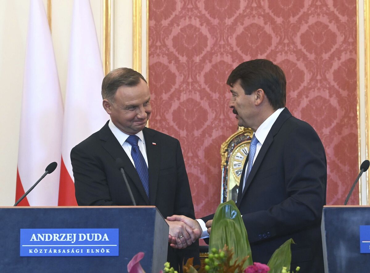 Polish President Andrzej Duda, left, and his Hungarian counterpart Janos Ader, right, shake hand after a joint press conference as part of a meeting at Alexander Palace in Budapest, Hungary, Thursday, Sept. 9, 2021. (Noemi Bruzak/MTI via AP)