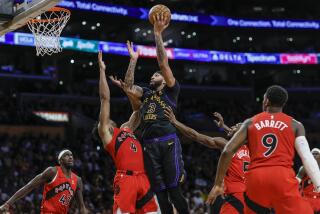 Lakers forward Anthony Davis shoots over Toronto Raptors forward Scottie Barnes during a basketball game.