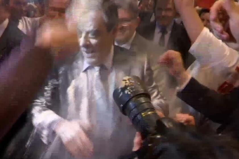 Conservative French presidential candidate Francois Fillon is doused with flour while arriving at a political meeting in the eastern city of Strasbourg, Thursday April 6, 2017. A young man wearing a T-shirt marked âStudents with Fillonâ was seen on BFM TV throwing flour at the candidate Thursday night as Fillon walked among supporters, completely covering Fillonâs face, shoulders and chest with white powder.(BFMTV via AP) MANDATORY CREDIT