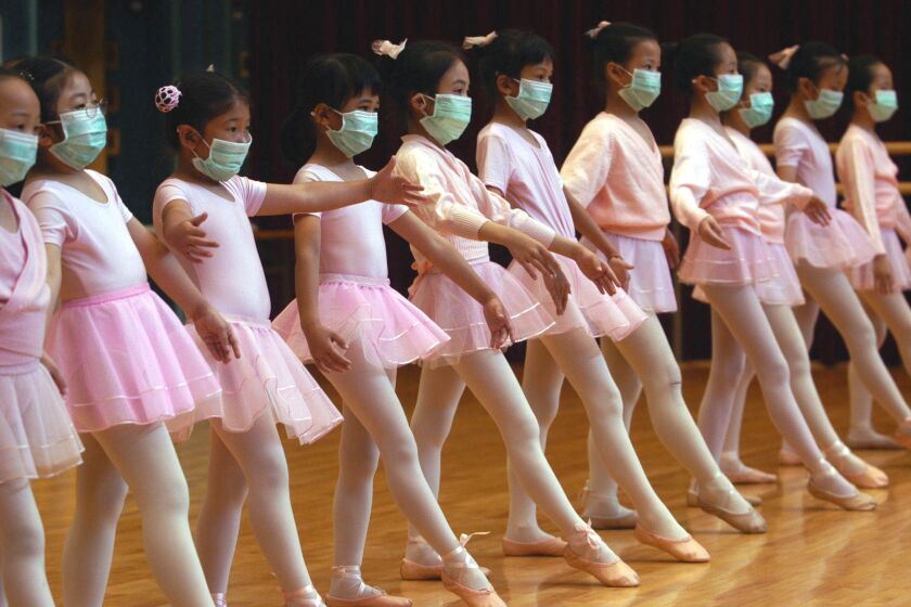 ** FOR USE AS DESIRED, PHOTOS OF THE DECADE ** FILE - Children attend ballet lessons wearing masks to protect themselves from severe acute respiratory syndrome, SARS, in Hong Kong, in this April 27, 2003 file photo. (AP Photo/Vincent Yu, File)