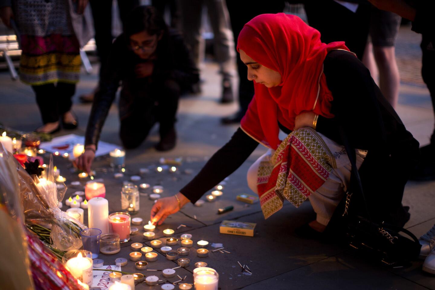 A woman lights candles after a vigil in Manchester, England, on May 23, 2017, the day after a suicide attack at an Ariana Grande concert that left 22 people dead.