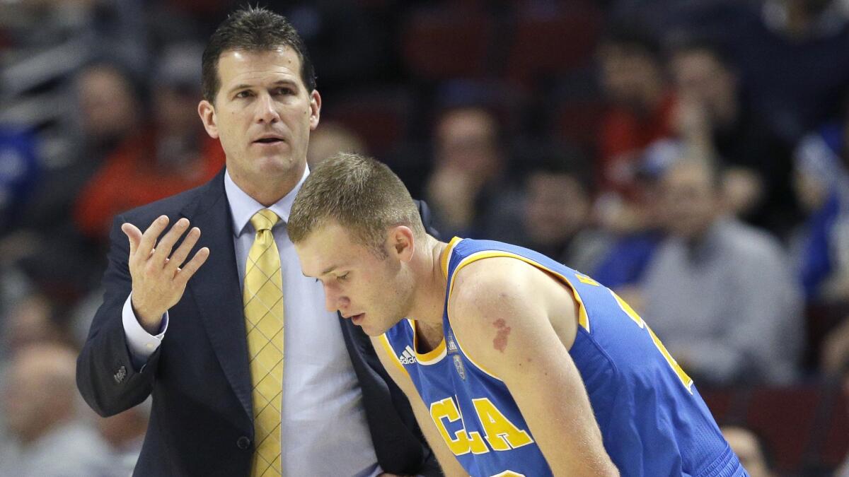 UCLA Coach Steve Alford, left, speaks to his son and guard Bryce Alford during the second half of an 83-42 loss to Kentucky in Chicago on Dec. 20.