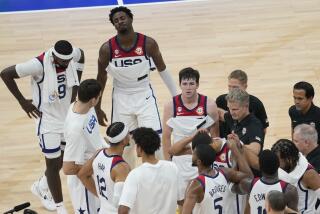 Austin Reaves, center, and teammates gather on the court after their loss to Germany 