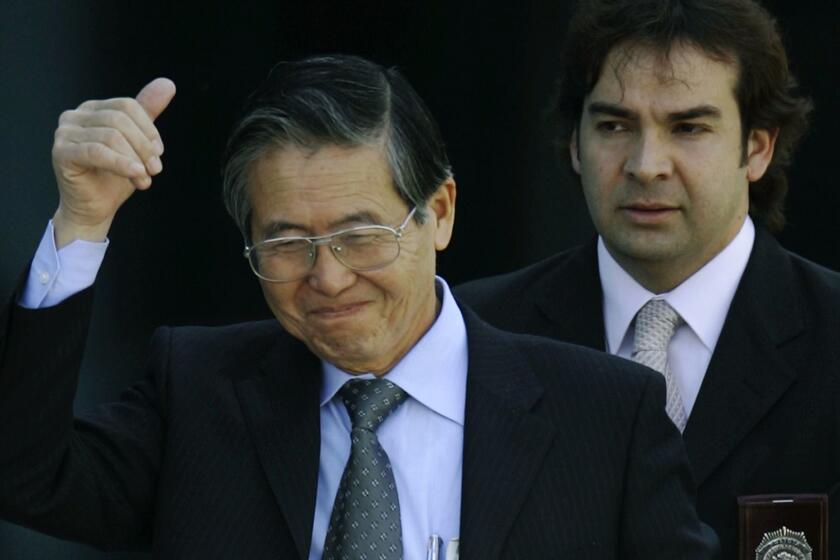Flanked by Chilean investigative police, former Peruvian President Alberto Fujimori gives a "thumbsup" sign as he leaves the Chilean investigative police academy in Santiago, Chile, Monday, Nov. 7, 2005. Fujimori was arrested in Chile Monday on charges at home involving corruption and massacres, as he attempted to return to Peru to run for reelection after five years as a protected exile in Japan. (AP Photo/Roberto Candia)