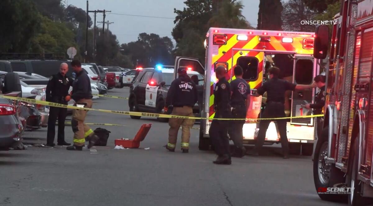 Firefighters and paramedics load a victim into an ambulance Tuesday next to site where he was shot in Barrio Logan.