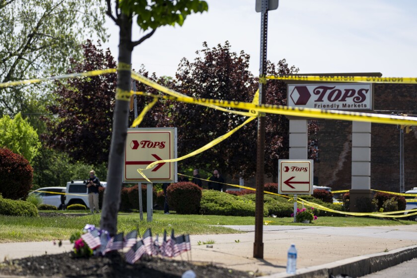 BUFFALO, NY - MAY 15: People gather outside the police tape at Tops Friendly Market at Jefferson Avenue and Riley Street on Sunday, May 15, 2022 in Buffalo, NY. The fatal shooting of 10 people at a grocery store in a historically Black neighborhood of Buffalo by a young white gunman is being investigated as a hate crime and an act of "racially motivated violent extremism," according to federal officials. (Kent Nishimura / Los Angeles Times)