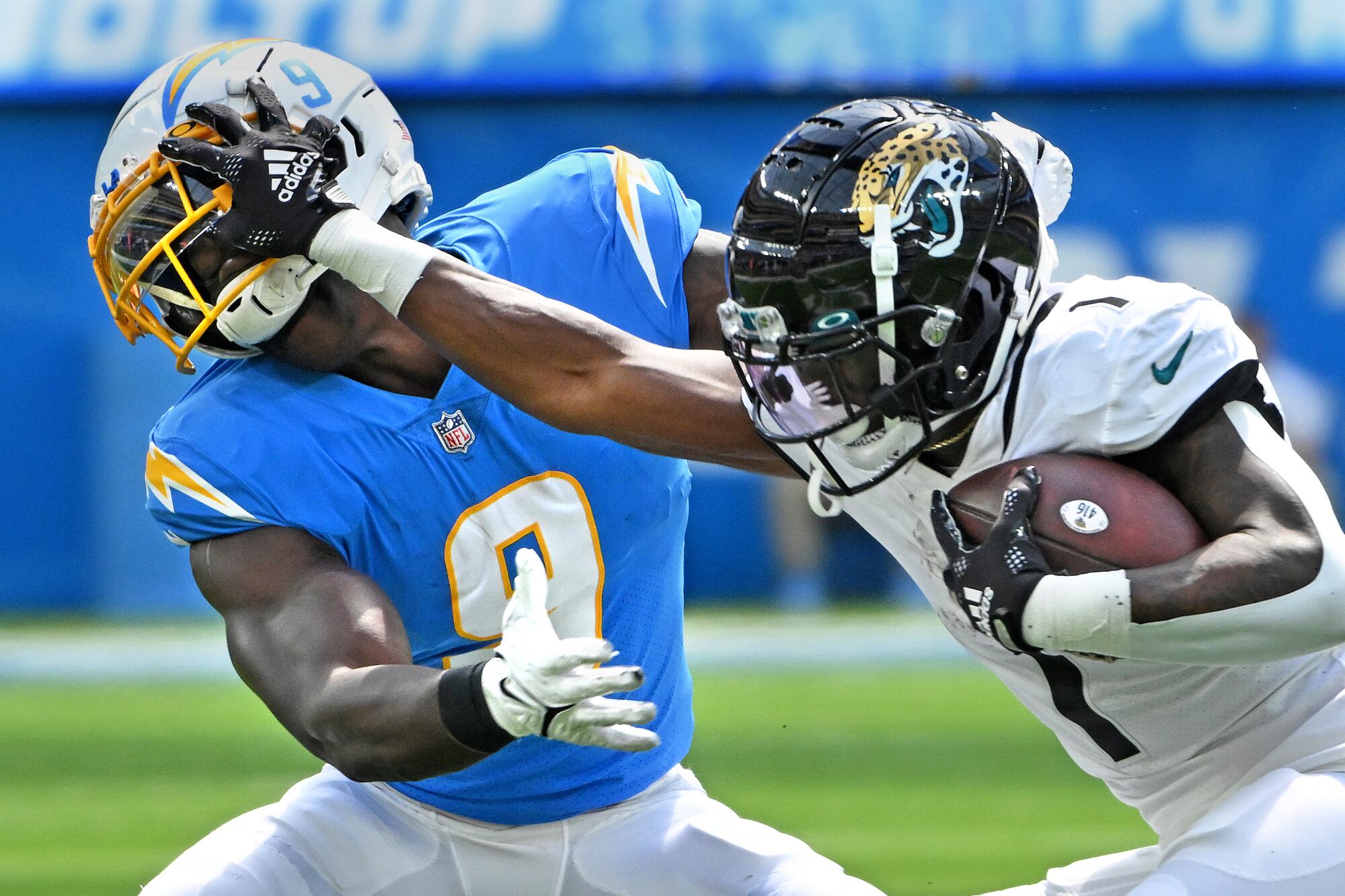 Jacksonville Jaguars running back Travis Etienne stiff arms Chargers linebacker Kenneth Murray.