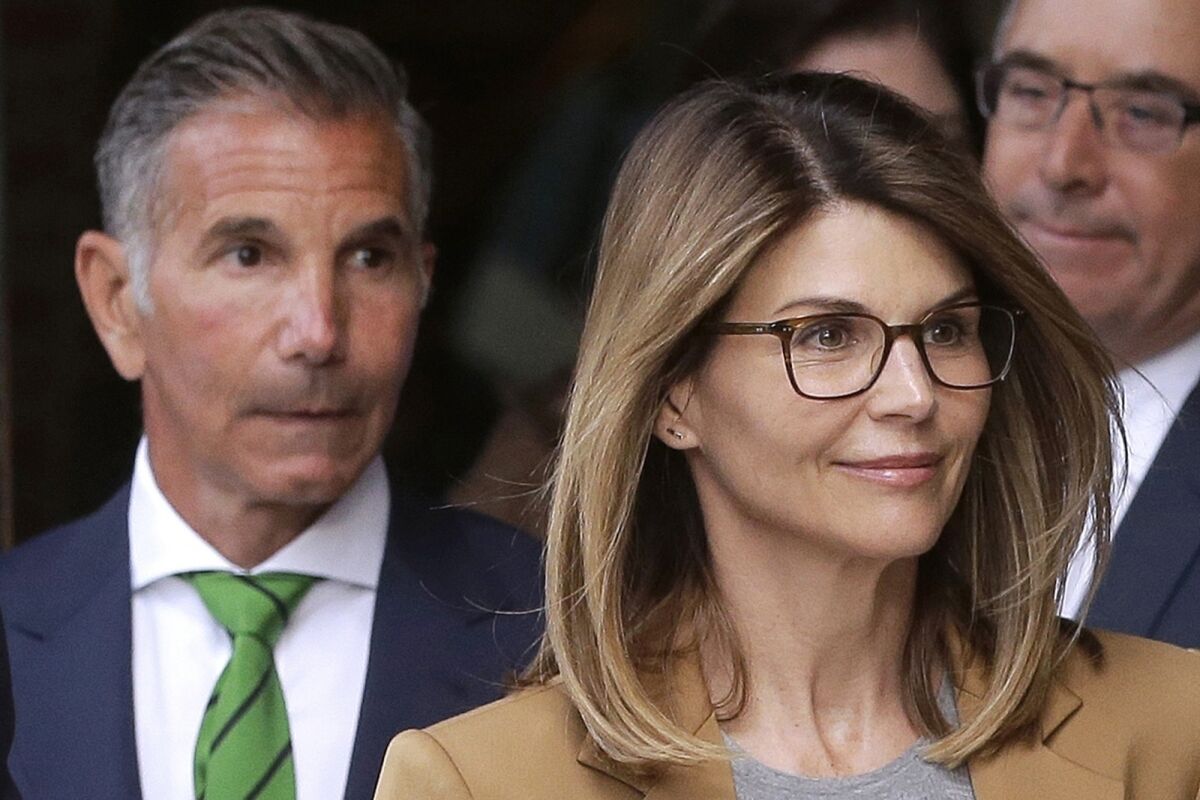 FILE - In this April 3, 2019, file photo, actress Lori Loughlin, front, and her husband, clothing designer Mossimo Giannulli, left, depart federal court in Boston after a hearing in a nationwide college admissions bribery scandal. In a court filing on Monday, July 13, 2020, lawyers for the couple, who admitted to paying $500,000 to get their daughters into the University of Southern California as fake crew recruits, asked a judge to lower their bail from $1 million to $100,000, saying they will not flee ahead of their August sentencing in the college admissions bribery case. (AP Photo/Steven Senne, File)