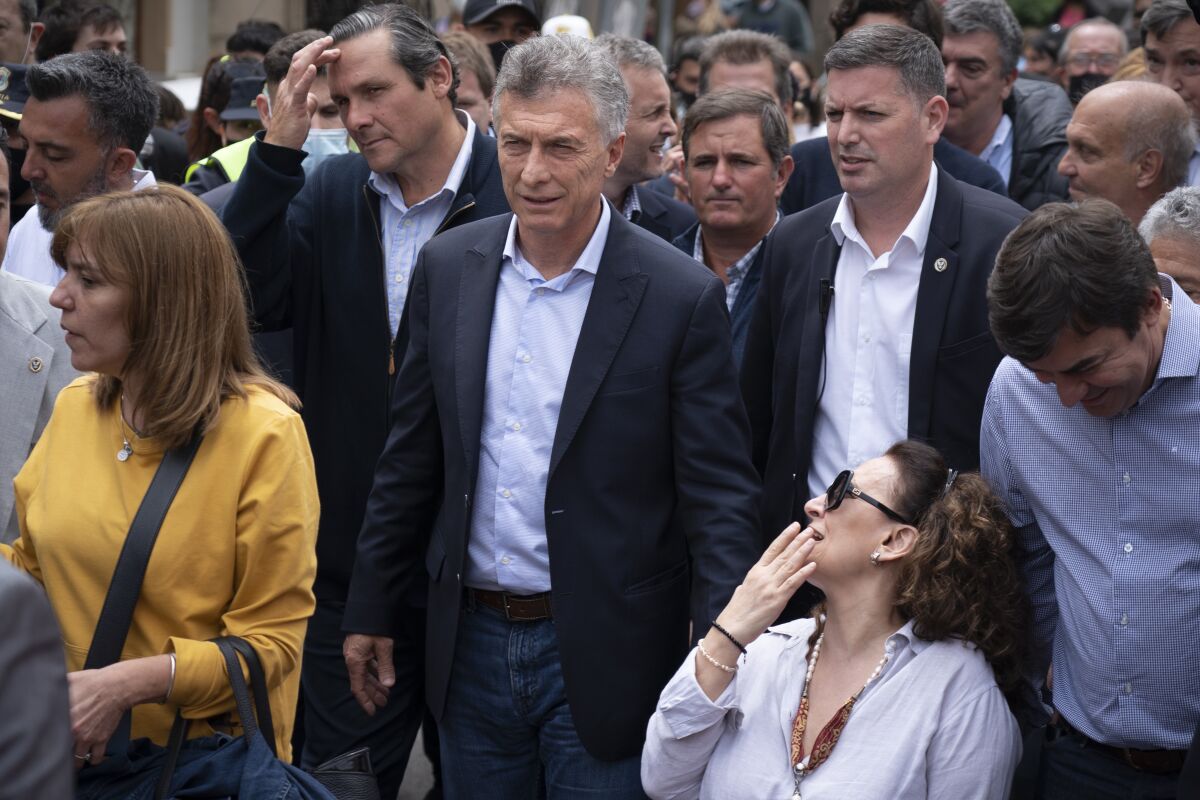Former Argentine President Mauricio Macri, center, arrives to court accompanied by former Vice President Marta Gabriela Michetti, lower right, in Dolores, Argentina, Wednesday, Nov. 3, 2021. Macri was summoned to court as a suspect in the case of alleged spying on the relatives of the crew-members who died in the ARA San Juan submarine in 2017. (AP Photo/Victor R. Caivano)