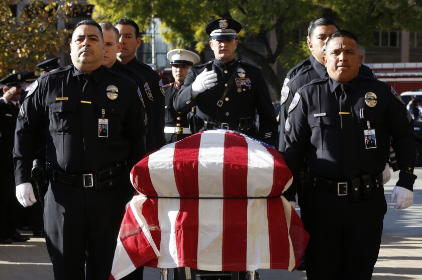 An honor guard carries the coffin of slain Downey Police Officer Ricardo Galvez at his funeral service at the Cathedral of Our Lady of Angels in Los Angeles on Nov. 30, 2015. 