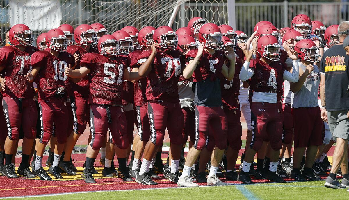 The La Cañada High football team gathers in the end zone for a warm-up during a recent preseason practice.