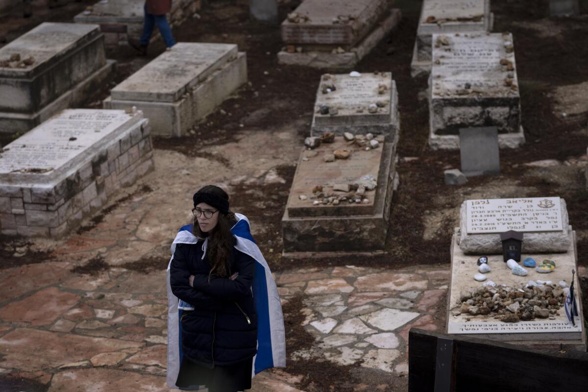 A mourner draped in the Israeli flag 