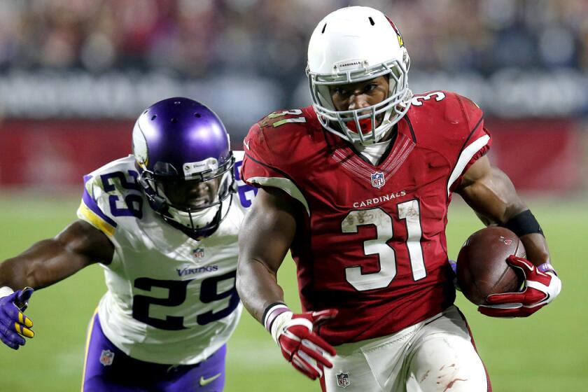 Arizona Cardinals running back David Johnson runs as Minnesota Vikings cornerback Xavier Rhodes pursues during the second half on Thursday.